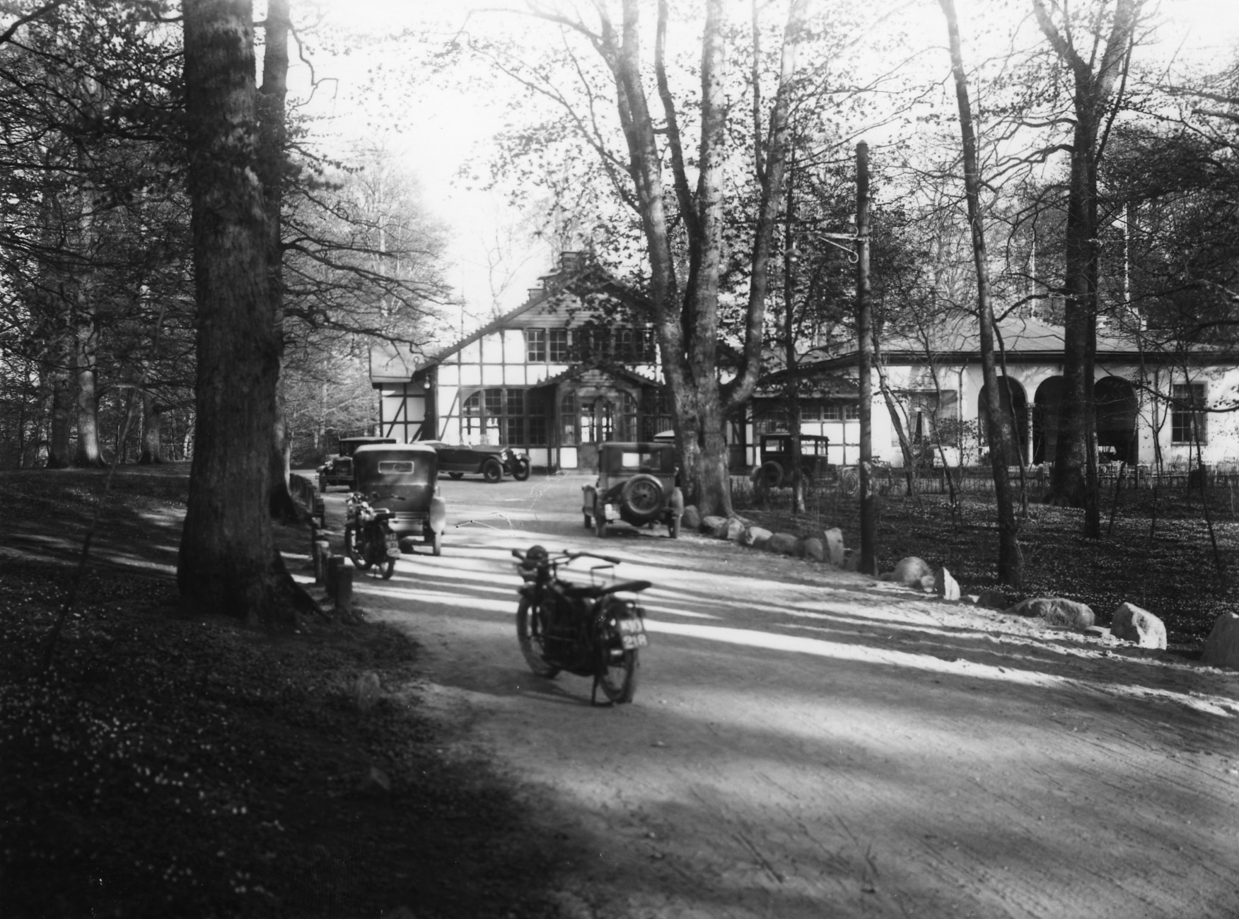 Slotspavillionen med bindingsværk med motorcykler og biler i gården, 1930&#039;erne