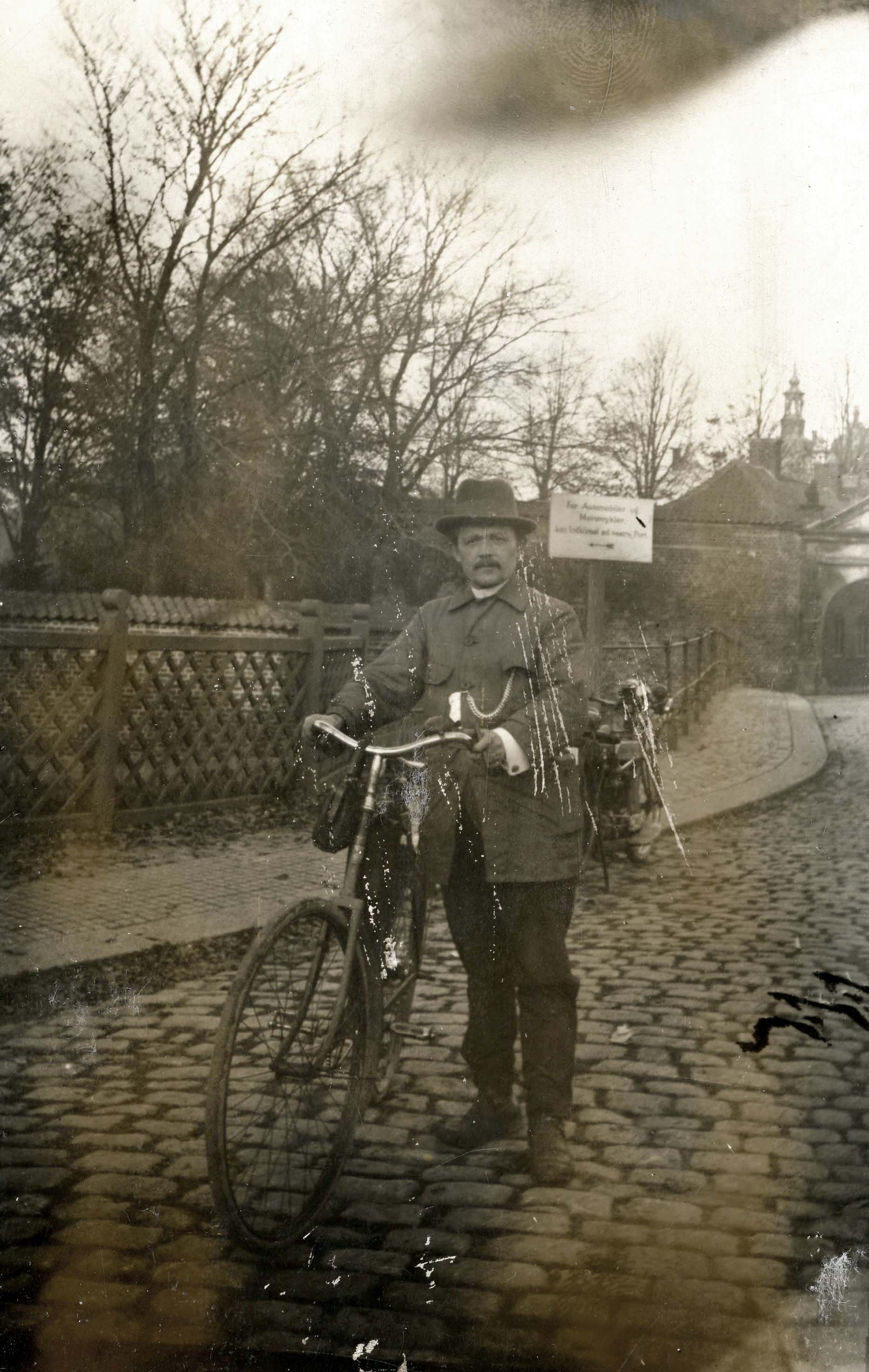 Mand med cykel fotograferet ved indgangen til slottet