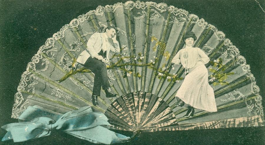 Postkortmotiv: Vifte med flæser og motiv af forelsket par på en blomstergren.
