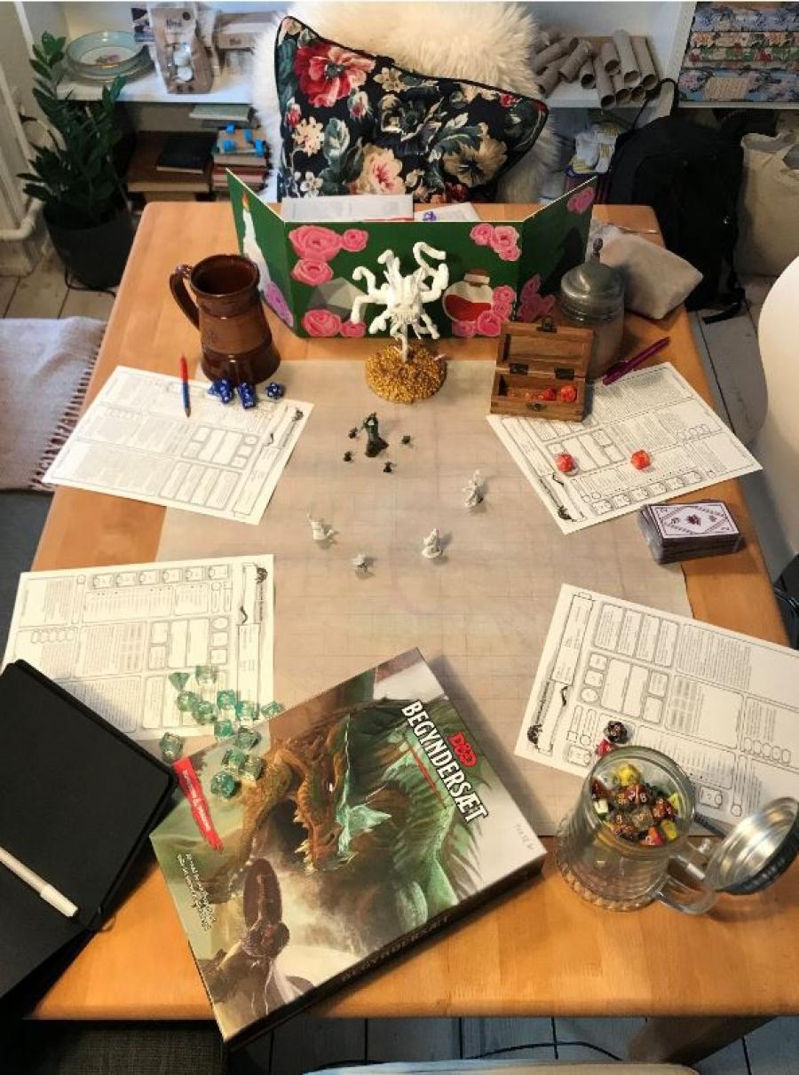 Et bord dækket op til et spil Dungeons & Dragons, med terninger, figurer og spilleark