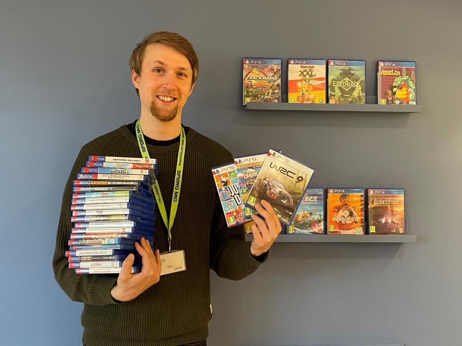 Bibliotekar Jacob Refstrup Hansen med stakkevis af Playstation-spil