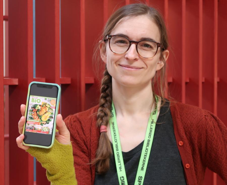 Børnebibliotekar Tanja Kate Jensen med smartphone der viser PressReader-app